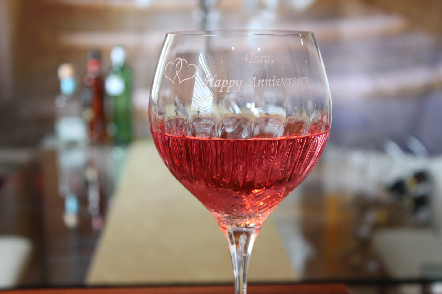 Glass with half-full drinks that has been personalized and engraved.