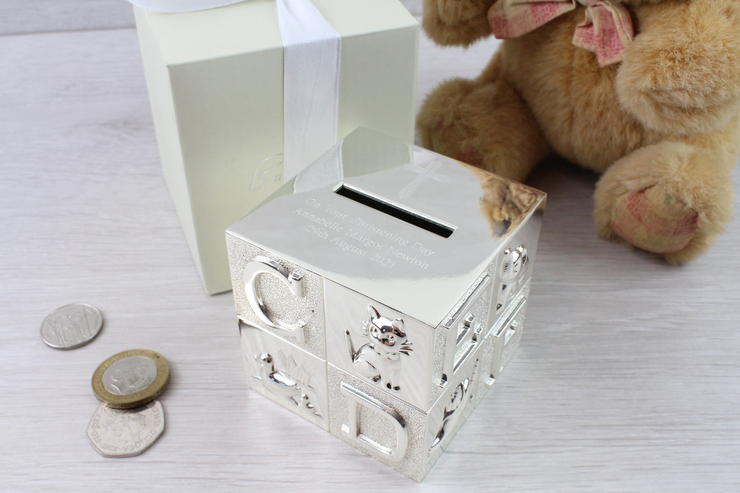 Closer image of money box showing ABC and animals with engraved cross