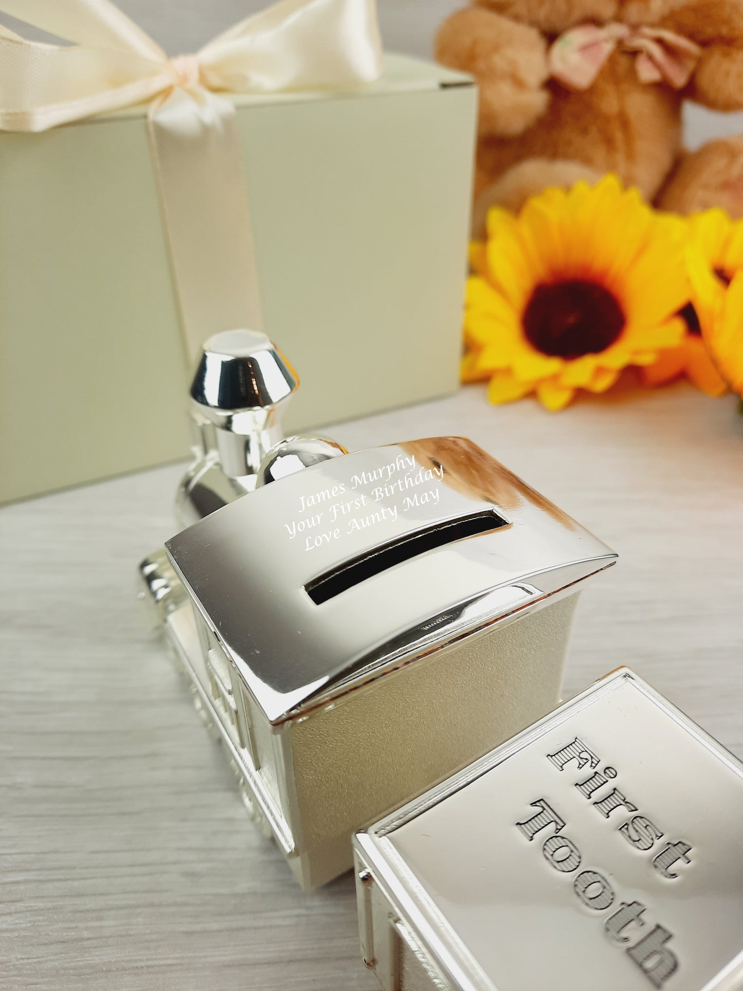 Close up shot of Personalised Engraved Money Box with Baby Tooth and Curl Train.