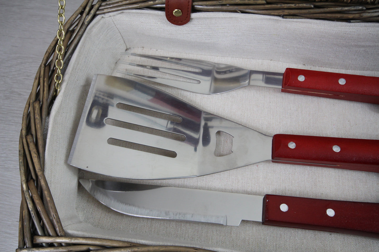 Close up shot of 3 barbecue tools (knife, spatula and fork) inside the case.