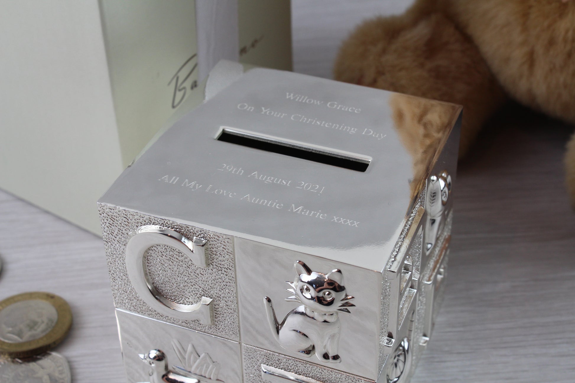 Close up of engraving on silver ABC and animal character money box